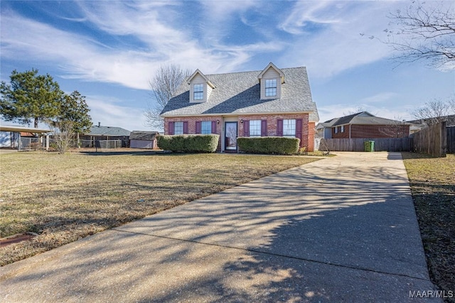 cape cod home featuring a front yard