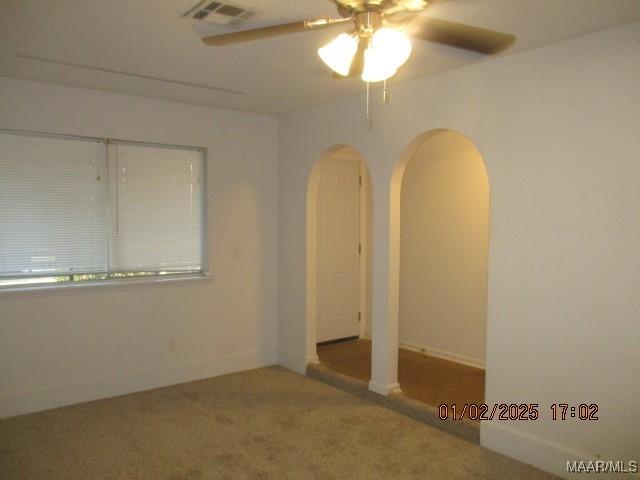 carpeted empty room featuring ceiling fan