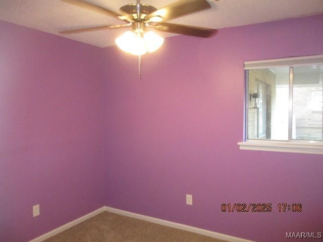 carpeted empty room featuring ceiling fan