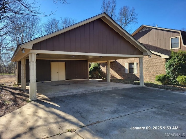 exterior space with a carport, brick siding, and driveway