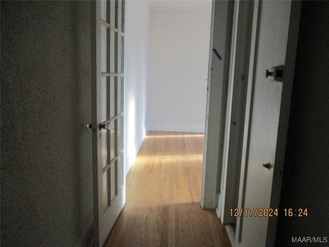 corridor with hardwood / wood-style flooring