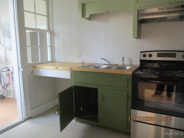 kitchen featuring sink, green cabinetry, electric range, butcher block counters, and extractor fan