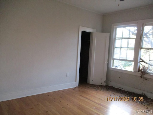 unfurnished room featuring plenty of natural light, ornamental molding, and light hardwood / wood-style flooring