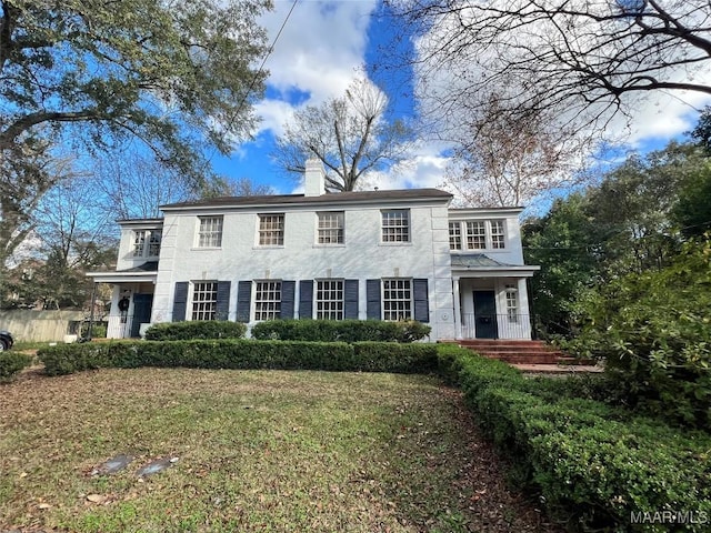 colonial-style house featuring a front lawn