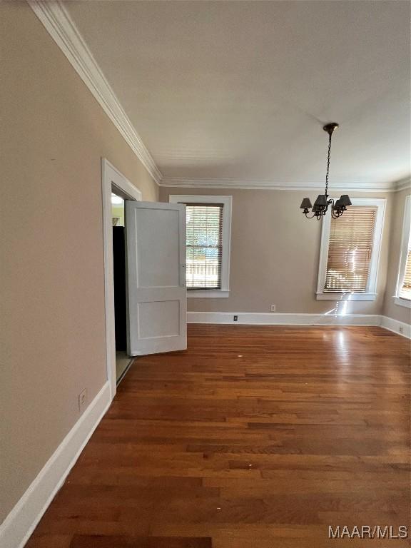 interior space with a notable chandelier, dark hardwood / wood-style flooring, and crown molding