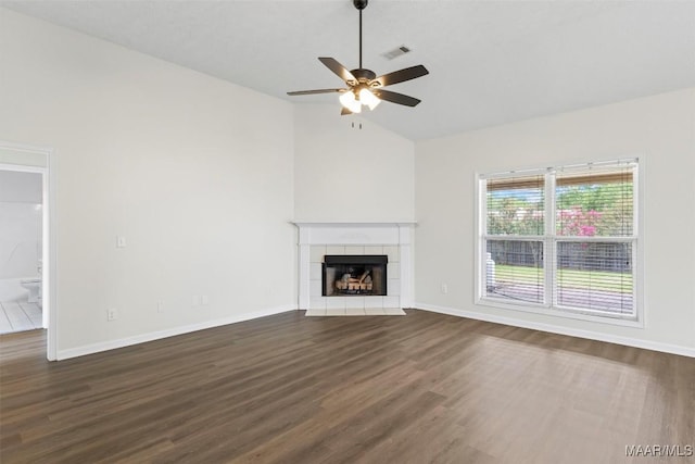 unfurnished living room with a tile fireplace, ceiling fan, dark wood-type flooring, and lofted ceiling