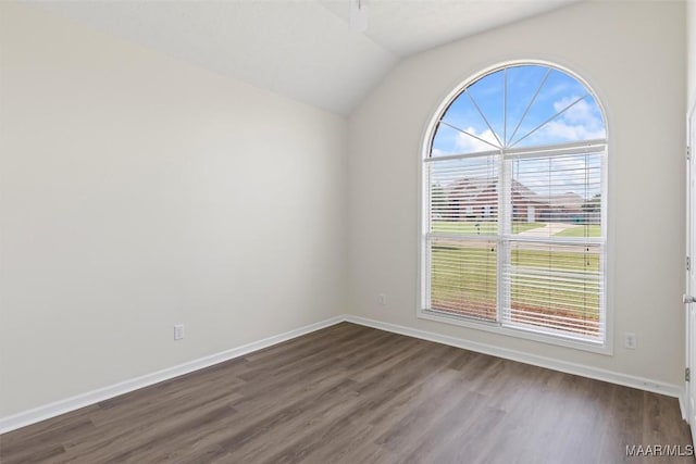 empty room with dark hardwood / wood-style floors and vaulted ceiling