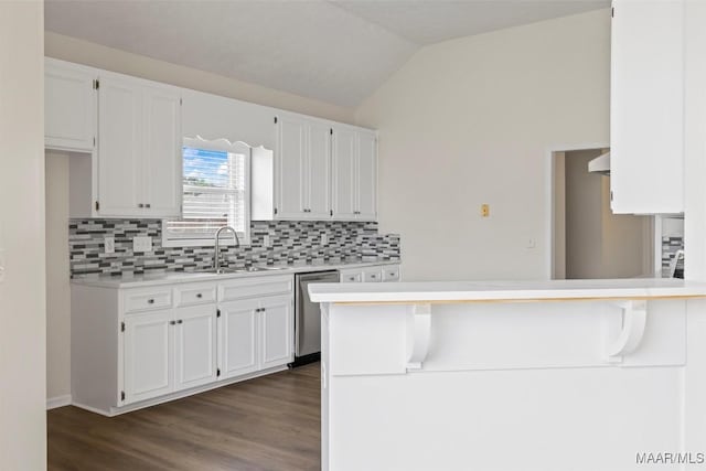 kitchen featuring stainless steel dishwasher, white cabinetry, sink, and vaulted ceiling