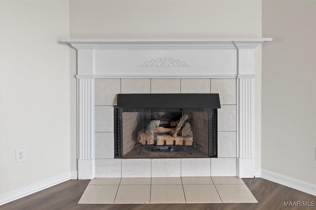 room details featuring a tile fireplace and wood-type flooring