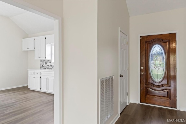 foyer featuring dark hardwood / wood-style flooring and lofted ceiling