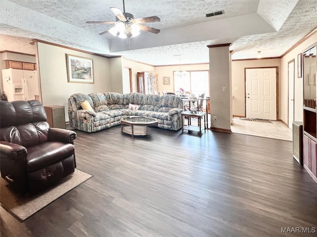 living room featuring a textured ceiling, a tray ceiling, dark hardwood / wood-style floors, and ornamental molding