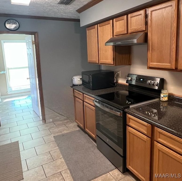 kitchen with dark stone counters, light tile patterned floors, a textured ceiling, stainless steel electric range oven, and ornamental molding