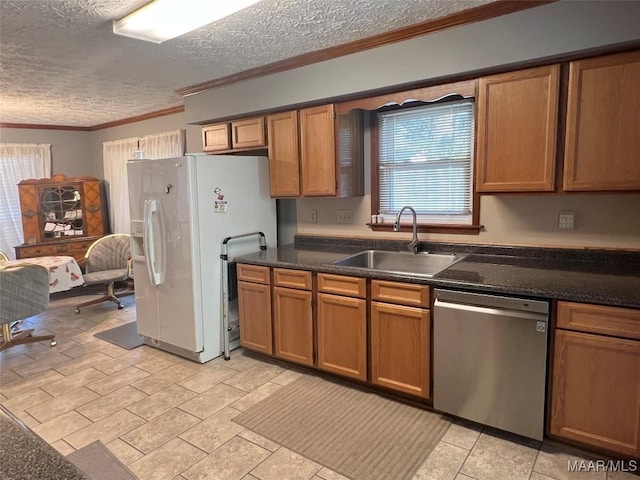 kitchen featuring dishwasher, white refrigerator with ice dispenser, sink, ornamental molding, and a textured ceiling