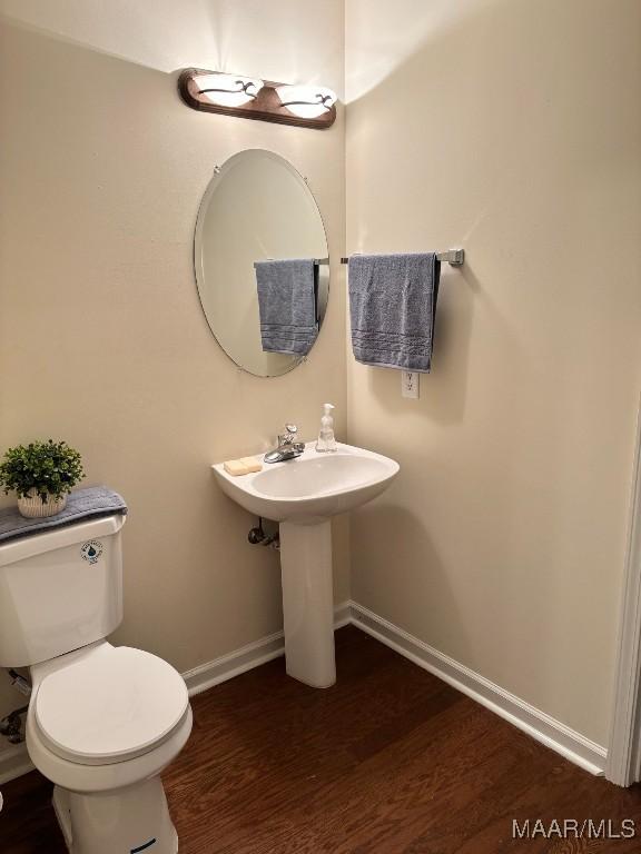 bathroom featuring toilet and wood-type flooring