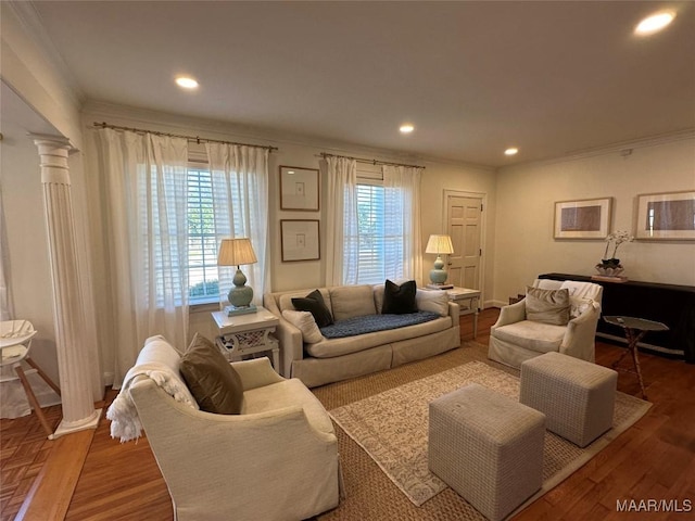 living room with ornate columns, crown molding, plenty of natural light, and hardwood / wood-style flooring