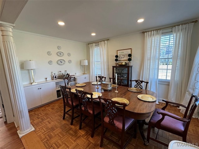 dining area with ornate columns, ornamental molding, and parquet flooring