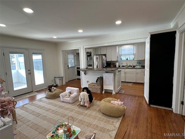 kitchen featuring french doors, hardwood / wood-style flooring, white cabinets, a center island, and stainless steel refrigerator