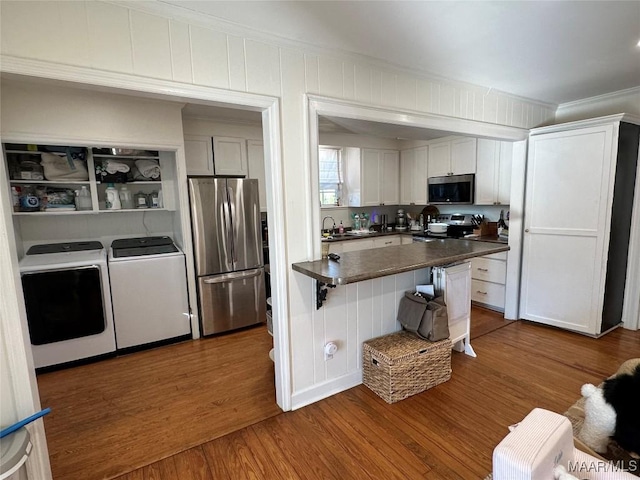 kitchen with white cabinetry, sink, stainless steel appliances, dark hardwood / wood-style flooring, and washer and dryer