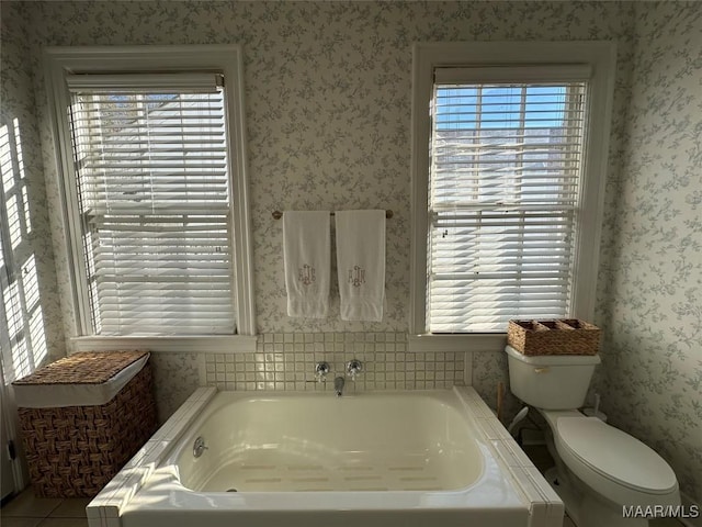 bathroom featuring tile patterned floors, toilet, and a bathing tub