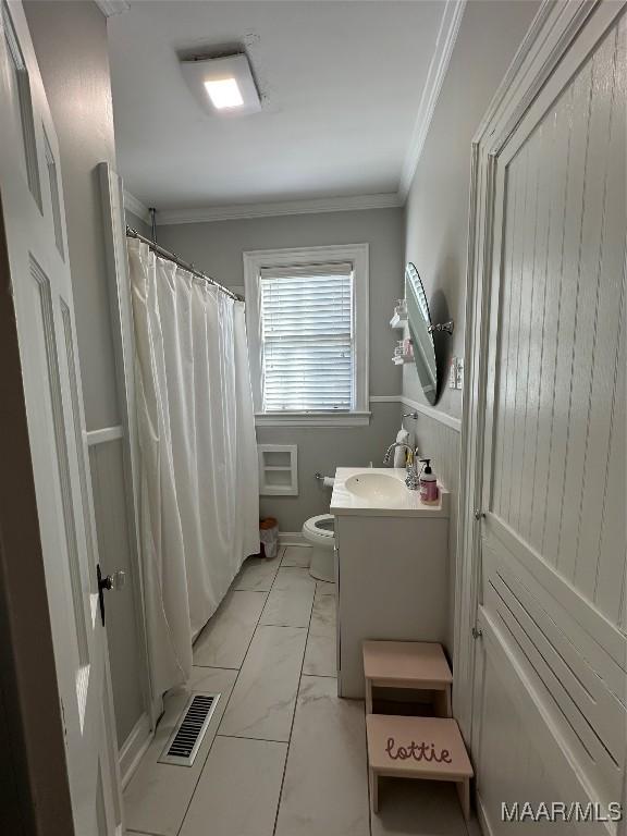 bathroom featuring vanity, toilet, and crown molding