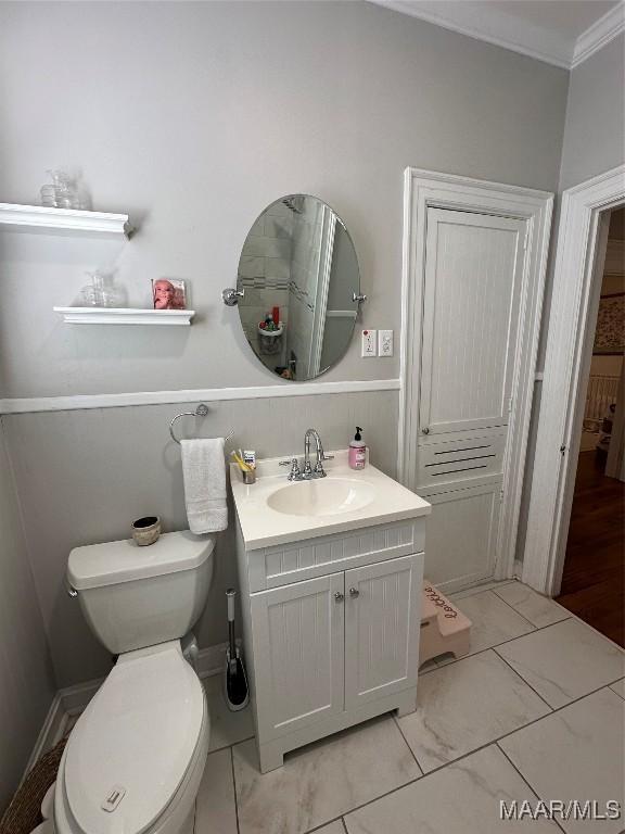 bathroom with vanity, ornamental molding, and toilet