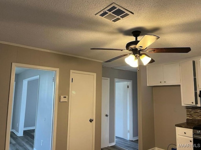 kitchen with ceiling fan, dark hardwood / wood-style floors, white cabinetry, and crown molding