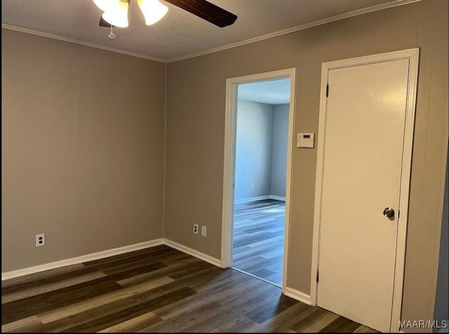 empty room with dark hardwood / wood-style flooring, ceiling fan, and crown molding