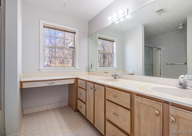 bathroom featuring tile patterned floors, a wealth of natural light, vanity, and a shower with shower door