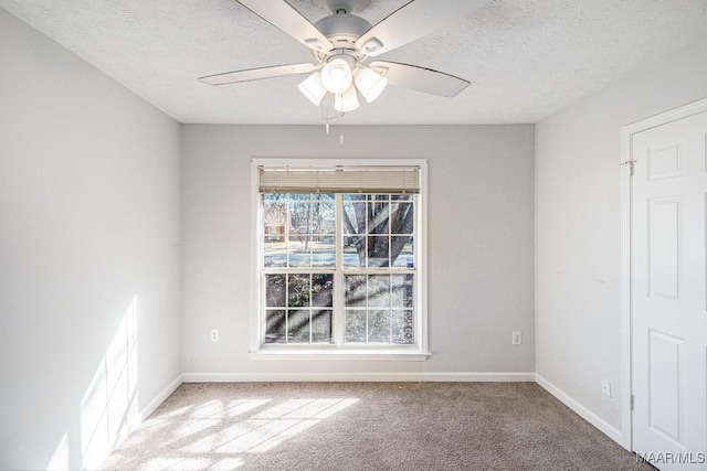 carpeted spare room with ceiling fan and a textured ceiling