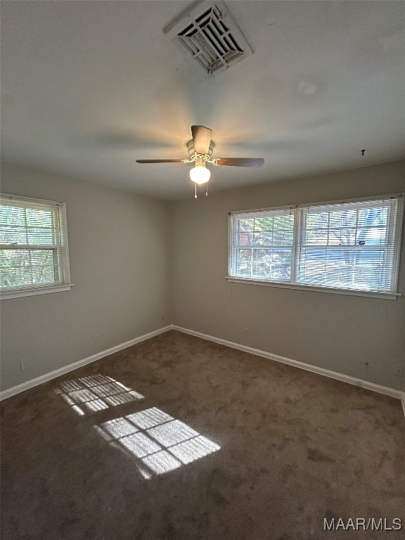 carpeted empty room featuring plenty of natural light and ceiling fan