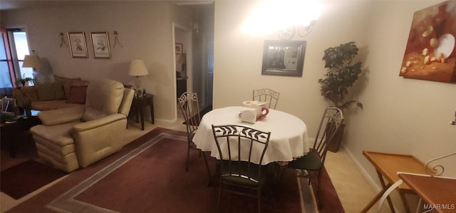 carpeted dining room with a notable chandelier