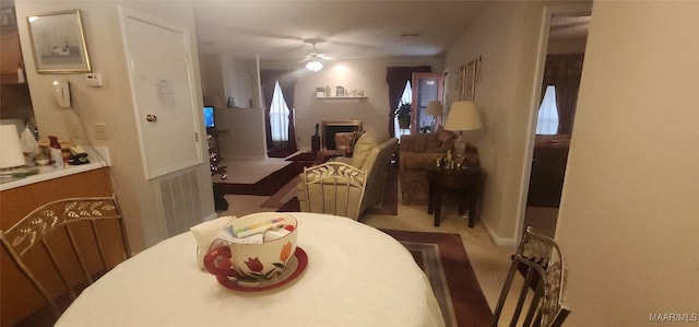 carpeted dining area featuring ceiling fan