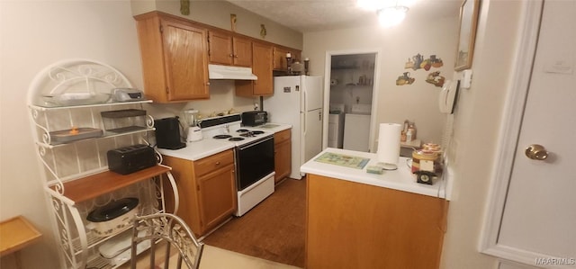 kitchen with washer and clothes dryer, dark hardwood / wood-style floors, white appliances, and a textured ceiling