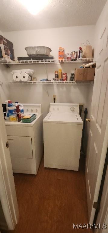 laundry room with dark hardwood / wood-style floors, washer and dryer, and a textured ceiling