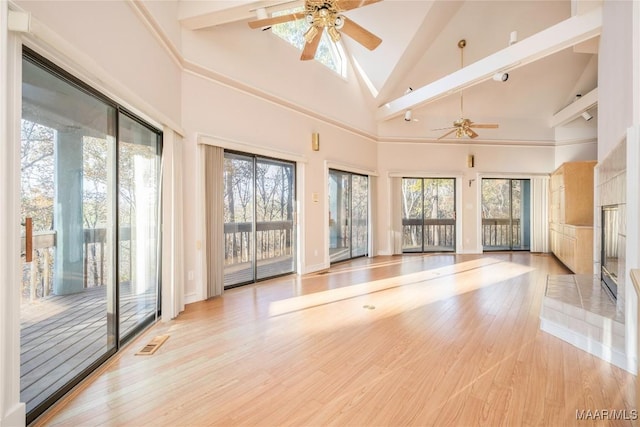 interior space with ceiling fan, a high ceiling, and light wood-type flooring