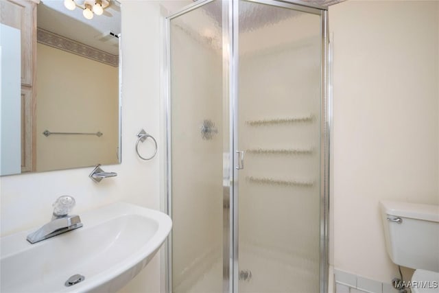 bathroom featuring toilet, sink, and walk in shower