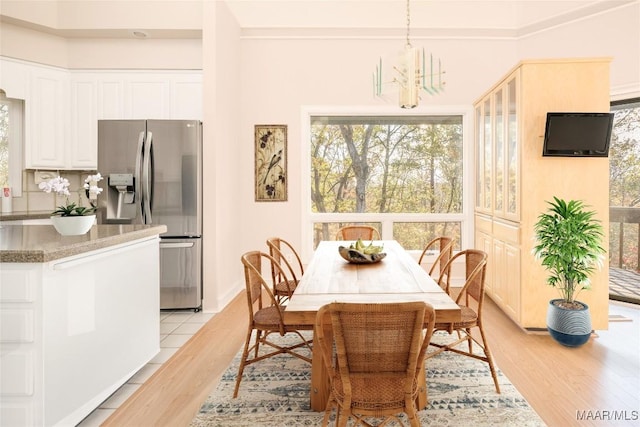 dining room with light hardwood / wood-style flooring and a notable chandelier