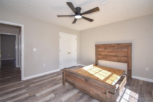 bedroom featuring ceiling fan, dark wood-type flooring, and a closet