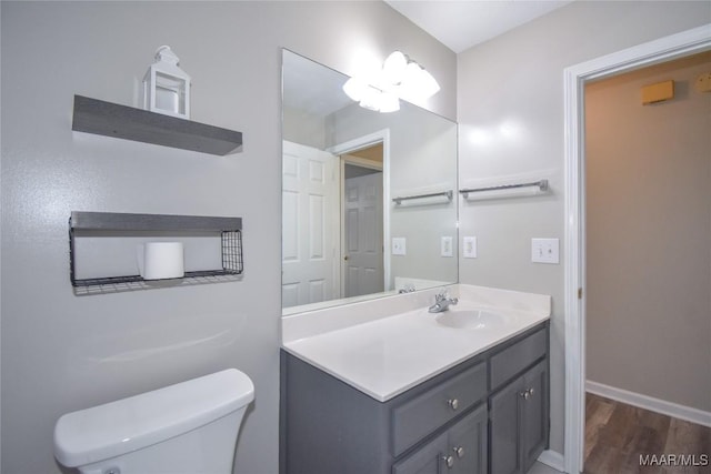 bathroom with wood-type flooring, vanity, and toilet