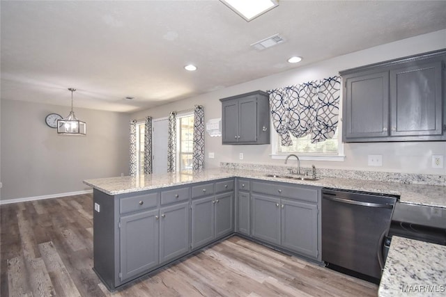 kitchen featuring kitchen peninsula, dishwasher, hanging light fixtures, hardwood / wood-style floors, and sink