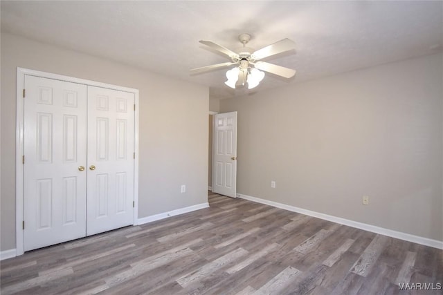 unfurnished bedroom with ceiling fan, light hardwood / wood-style floors, and a closet