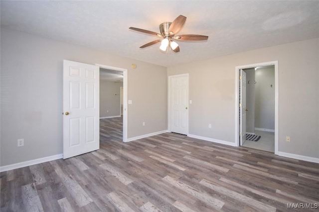 unfurnished bedroom with ensuite bathroom, a textured ceiling, ceiling fan, and dark hardwood / wood-style flooring