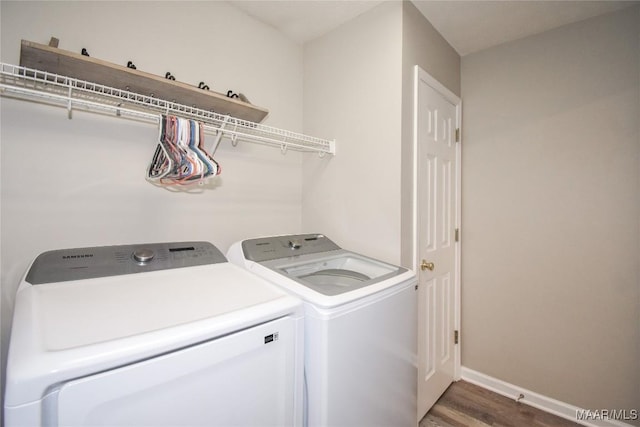 laundry area with dark hardwood / wood-style floors and washing machine and clothes dryer