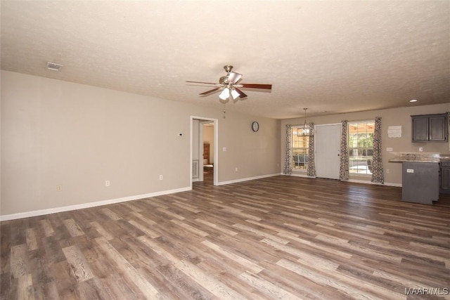 unfurnished living room featuring a textured ceiling, ceiling fan, and dark hardwood / wood-style flooring