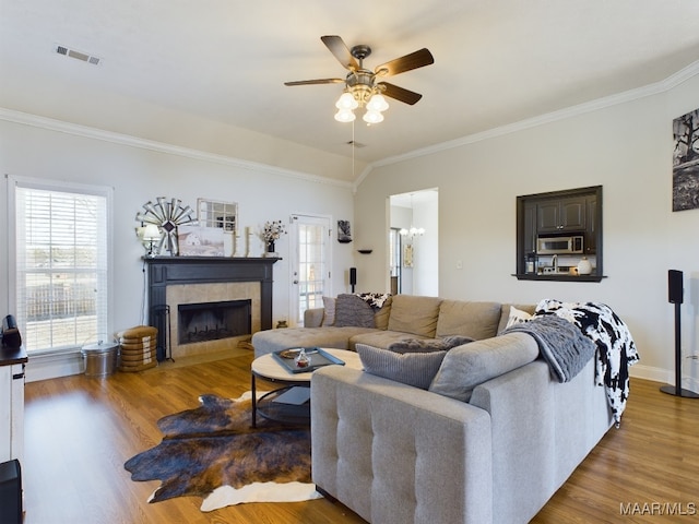 living room with ceiling fan with notable chandelier, dark hardwood / wood-style flooring, and ornamental molding