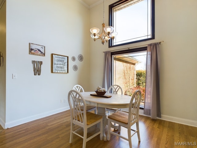 dining space with ornamental molding, dark hardwood / wood-style flooring, plenty of natural light, and a notable chandelier