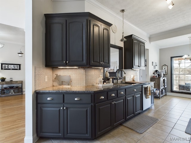 kitchen featuring dishwasher, sink, backsplash, pendant lighting, and ornamental molding