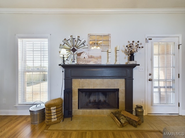 room details featuring a tiled fireplace, hardwood / wood-style floors, and ornamental molding