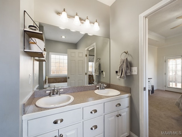 bathroom featuring a bath, vanity, a wealth of natural light, and crown molding