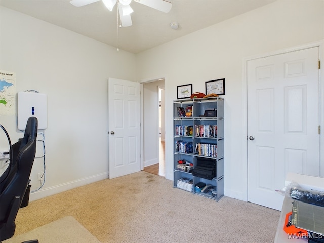 carpeted home office featuring ceiling fan